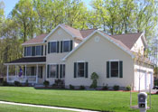 Autumn Builders two-story home with covered porch on a wooded lot